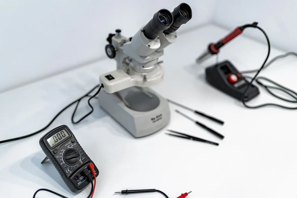 Technician using a microscope workbench for detailed component inspection